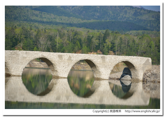 タウシュベツ橋梁、静止した水面に映る丸いアーチ（北海道上士幌町）